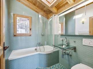 Step into this stunning bathroom, featuring a unique design with a corner bathtub and a glass sink.