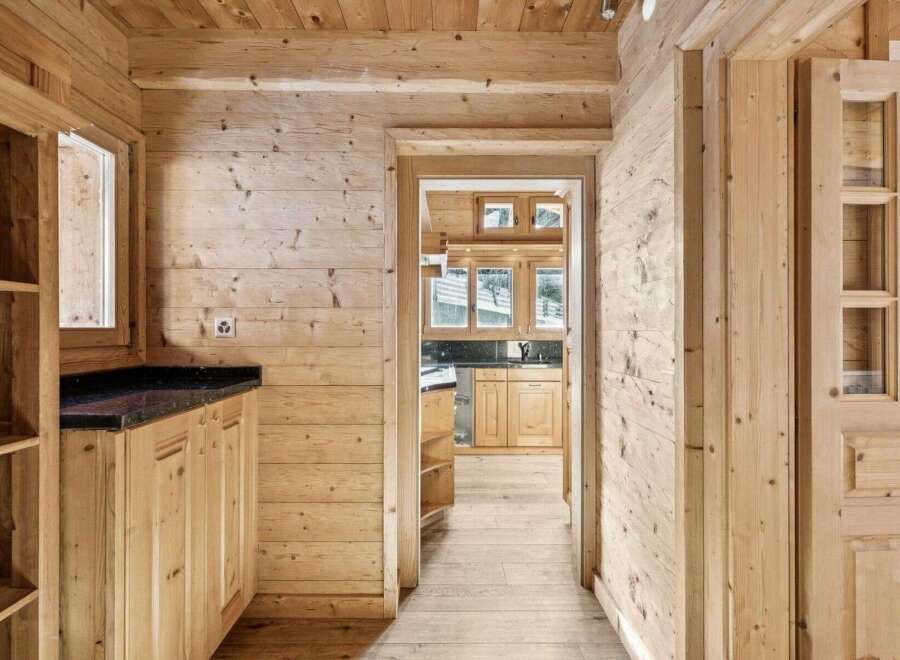 Step into rustic elegance with this stunning property featuring warm wooden interiors and a welcoming hallway.