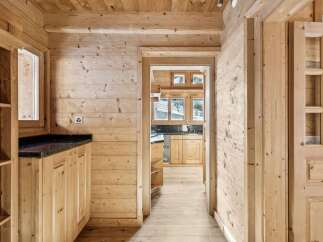 Step into rustic elegance with this stunning property featuring warm wooden interiors and a welcoming hallway.