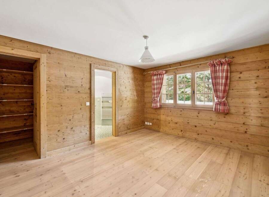 This charming property boasts a warm and inviting interior, featuring beautiful wooden walls and flooring that create a cozy atmosphere.