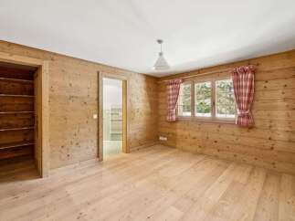 This charming property boasts a warm and inviting interior, featuring beautiful wooden walls and flooring that create a cozy atmosphere.