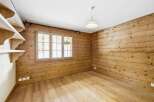 This charming room features beautiful wooden walls and flooring, creating a warm and inviting atmosphere.