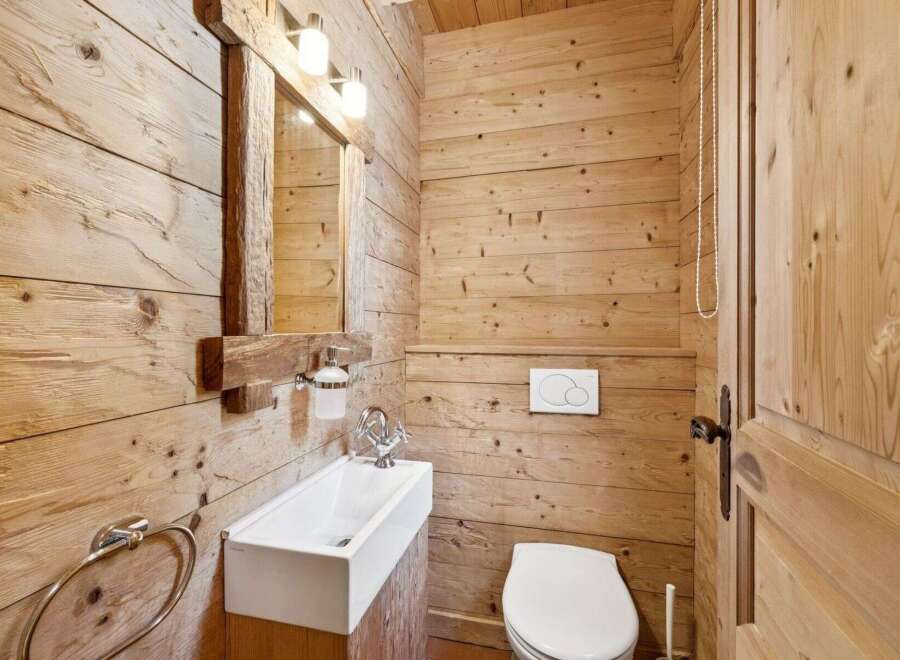 This stunning bathroom showcases a rustic design with wooden paneling, creating a warm and inviting atmosphere.