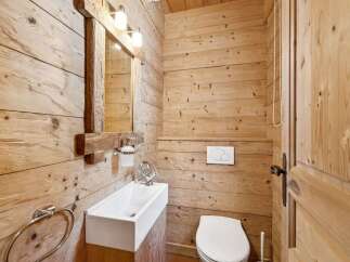 This stunning bathroom showcases a rustic design with wooden paneling, creating a warm and inviting atmosphere.