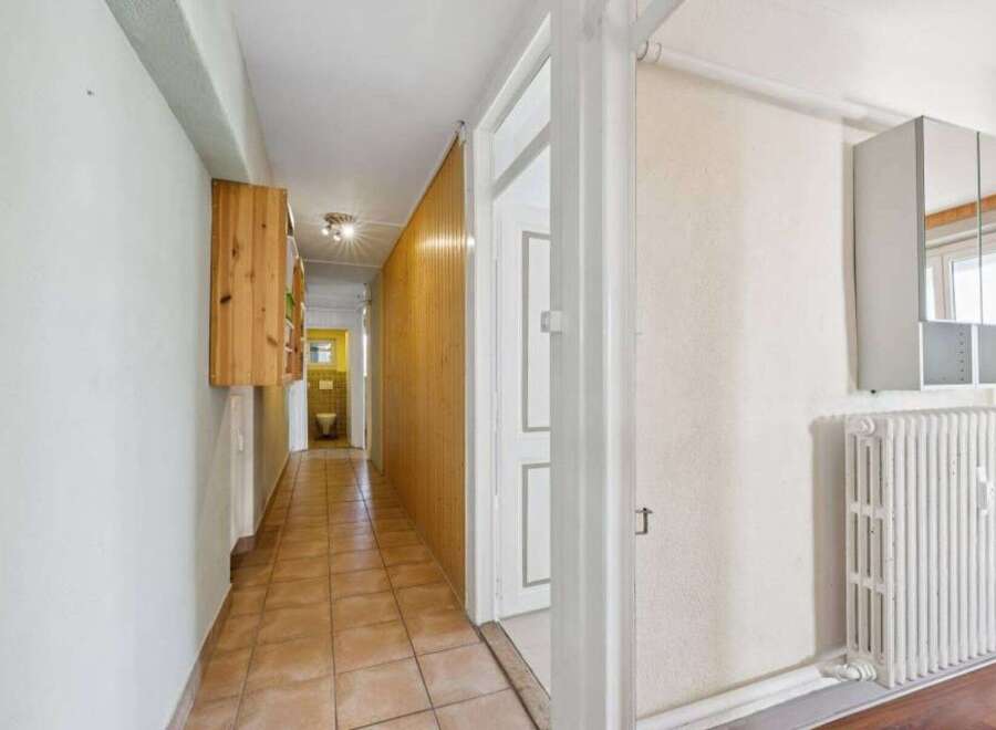Step into this inviting hallway, featuring a warm, tiled floor that leads your eye towards the back.