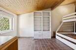 This charming room features a unique wooden ceiling and tiled flooring, creating a warm and inviting atmosphere.