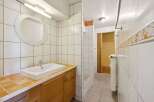 This bathroom features a clean and modern design with white tiles and a sleek sink.