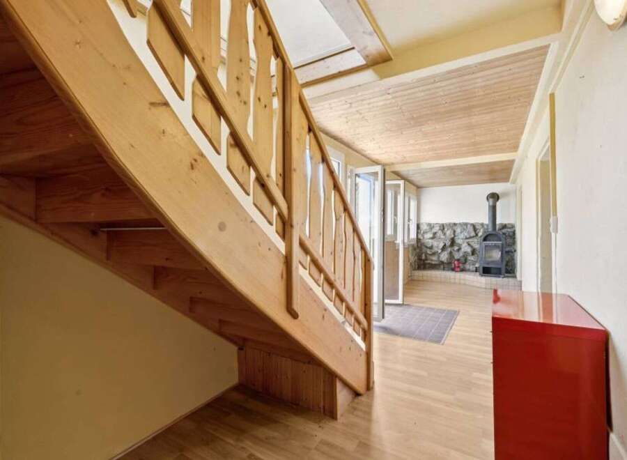 This charming property features a beautifully crafted wooden staircase, adding warmth and character to the interior.