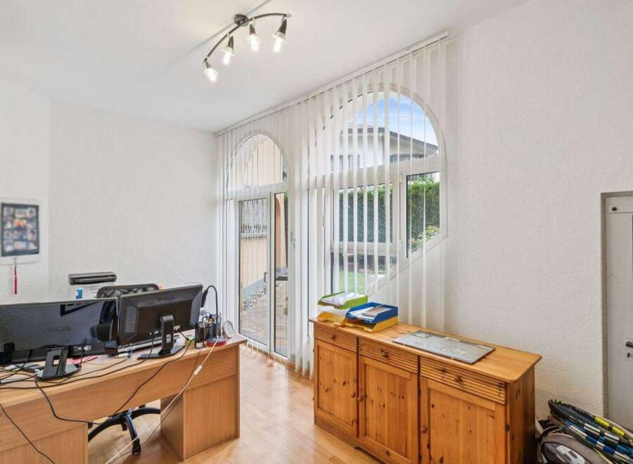 This home office features a spacious wooden desk with dual monitors, perfect for productivity.
