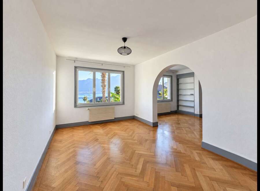 Experience breathtaking lake and mountain views from this charming living space, featuring a beautiful herringbone hardwood floor that adds warmth and elegance.
