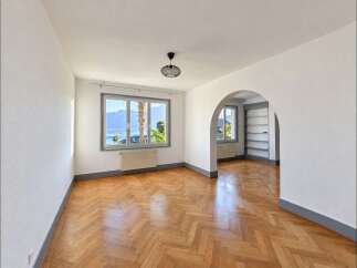Experience breathtaking lake and mountain views from this charming living space, featuring a beautiful herringbone hardwood floor that adds warmth and elegance.