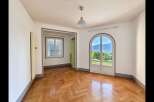 Experience breathtaking lake and mountain views from this stunning room, featuring a charming arched doorway that opens to the outdoors.