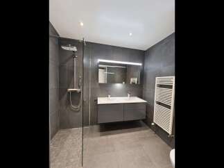 Experience modern luxury in this stunning bathroom featuring a spacious walk-in shower with a rainfall showerhead and sleek glass enclosure.