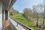 Enjoy breathtaking views from this stunning property! This home features a spacious balcony overlooking a lush green landscape and mature trees.