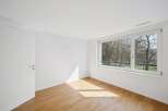 This bright and airy room features a large window that offers stunning views of the surrounding trees.