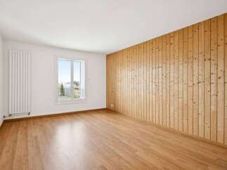 This inviting space features a stunning wooden accent wall that adds warmth and character.