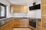 This modern kitchen features beautiful natural wood cabinetry that adds warmth and character to the space.