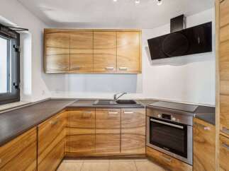This modern kitchen features beautiful natural wood cabinetry that adds warmth and character to the space.