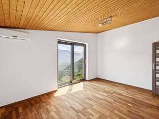 Experience breathtaking mountain views from this stunning room, featuring a modern sliding glass door that floods the space with natural light.