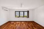 Experience breathtaking mountain views from this spacious room, featuring a beautiful hardwood floor and a large triple-pane window.