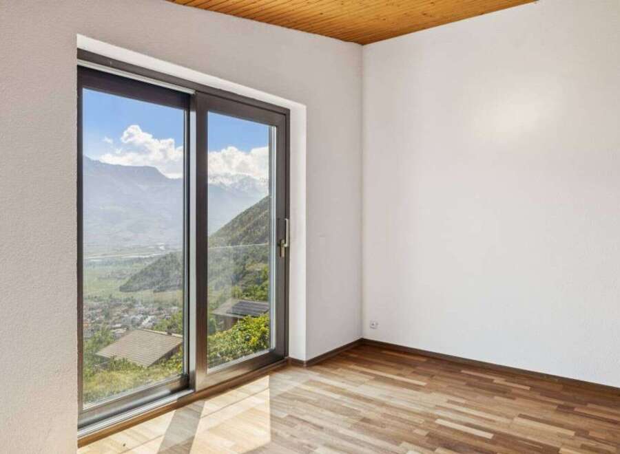 Experience breathtaking mountain views from this stunning room, featuring a large sliding glass door that floods the space with natural light.