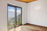 Experience breathtaking mountain views from this stunning room, featuring a large sliding glass door that floods the space with natural light.
