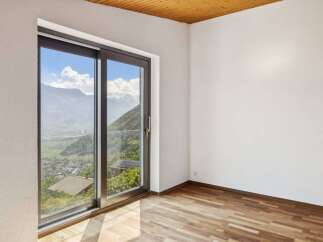 Experience breathtaking mountain views from this stunning room, featuring a large sliding glass door that floods the space with natural light.