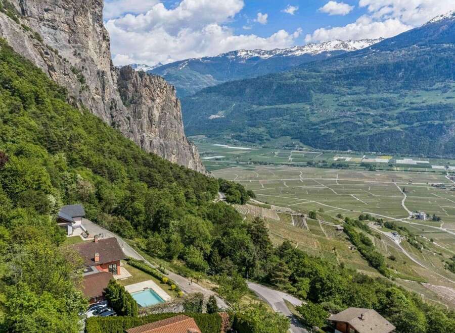 Experience breathtaking panoramic views from this stunning property nestled against a dramatic cliff face.