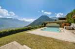 Experience luxury living with this stunning property featuring a pristine swimming pool and a relaxing hot tub, all set against a breathtaking mountain backdrop.