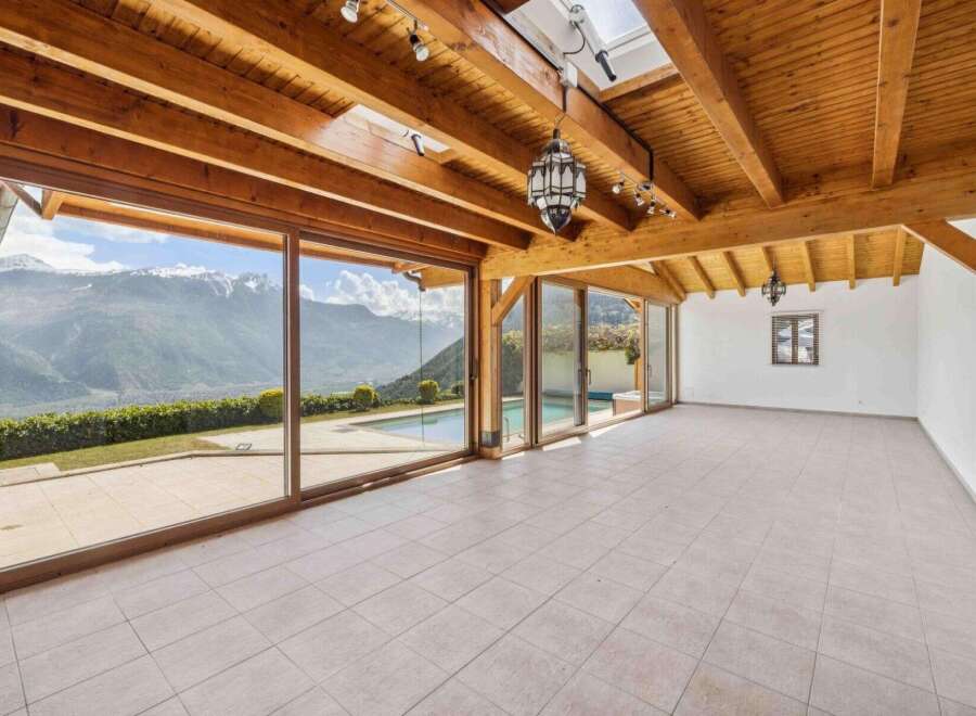 Experience breathtaking mountain views from this stunning property, featuring expansive glass walls that seamlessly blend indoor and outdoor living.