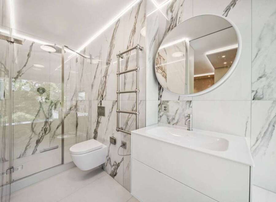 Step into luxury with this stunning bathroom featuring exquisite marble tile and modern fixtures.