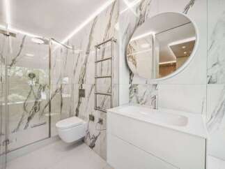 Step into luxury with this stunning bathroom featuring exquisite marble tile and modern fixtures.