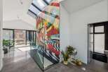 This stunning property boasts a modern interior with a vibrant mural accent wall, creating a unique and artistic atmosphere.