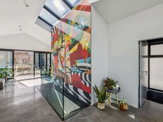 This stunning property boasts a modern interior with a vibrant mural accent wall, creating a unique and artistic atmosphere.