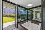 Indulge in luxury with this stunning property featuring a modern bathroom with a jacuzzi and expansive windows.