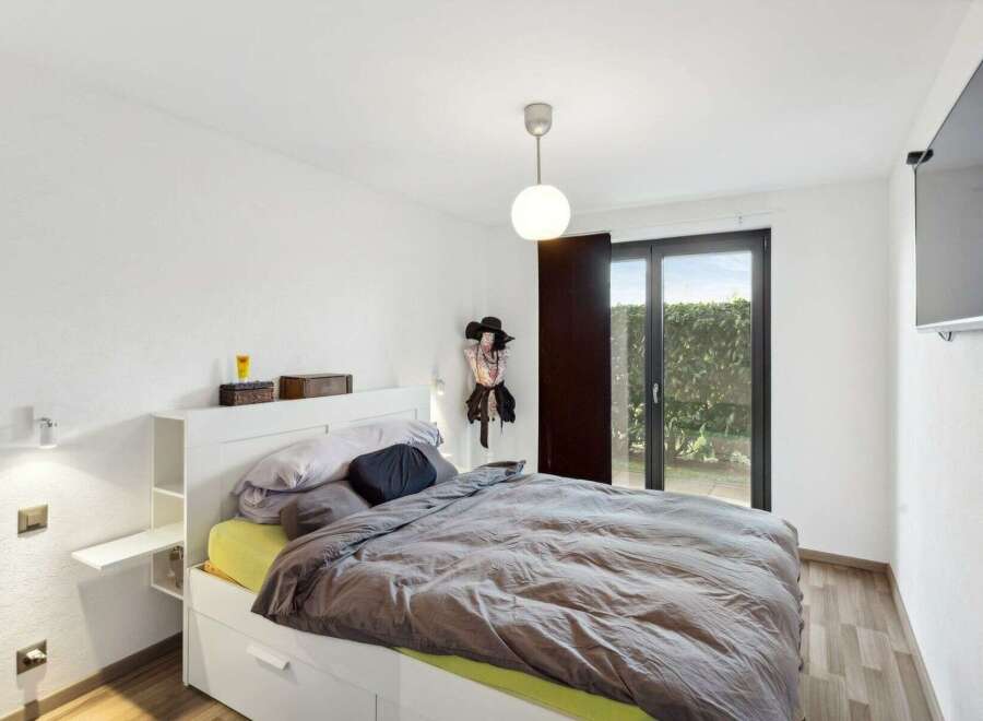 This modern bedroom offers a serene retreat with its minimalist design and ample natural light.