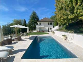 Discover luxury living in this stunning property featuring a private pool and lush landscaping.