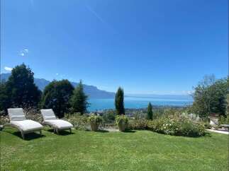 Enjoy breathtaking views from this stunning property! Featuring a lush green lawn, comfortable lounge chairs, and meticulously maintained landscaping, this home offers the perfect blend of luxury and tranquility.