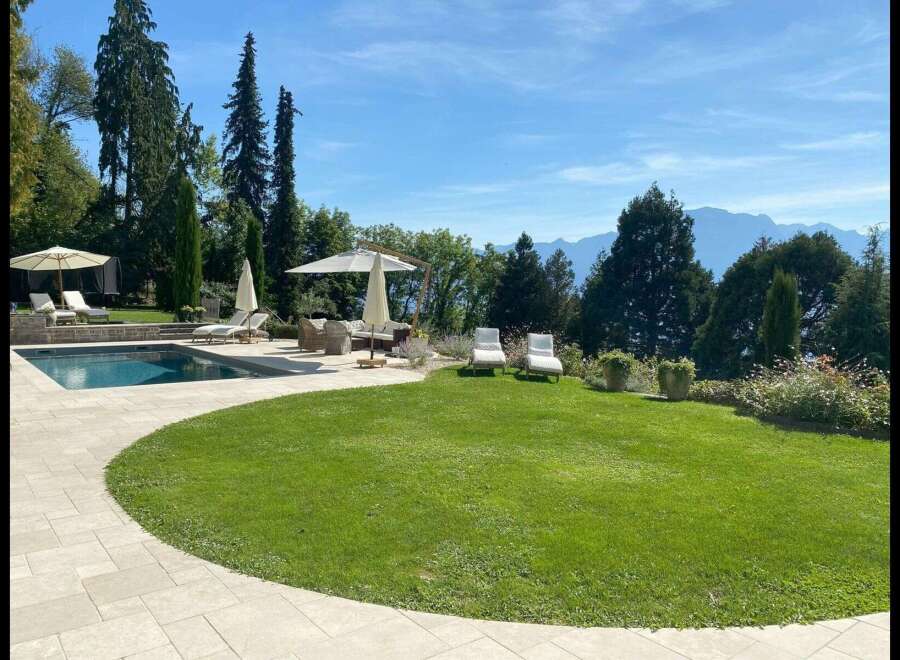 Experience luxury living in this stunning property featuring a private pool, lush green lawn, and breathtaking mountain views.