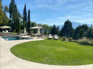 Experience luxury living in this stunning property featuring a private pool, lush green lawn, and breathtaking mountain views.