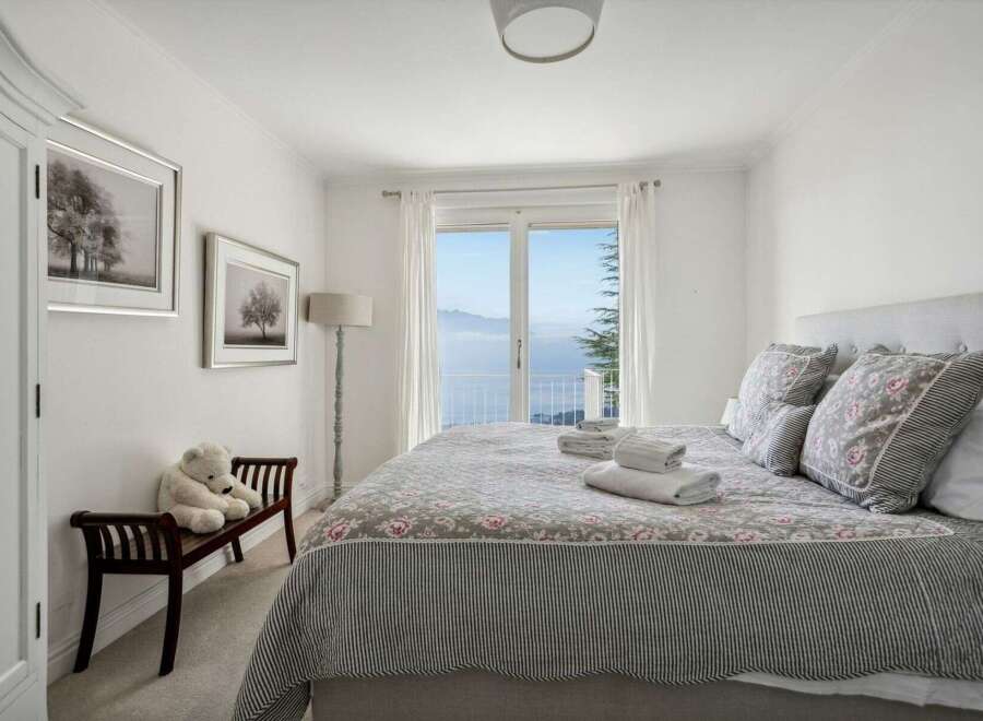 This charming bedroom offers a serene retreat with stunning views.