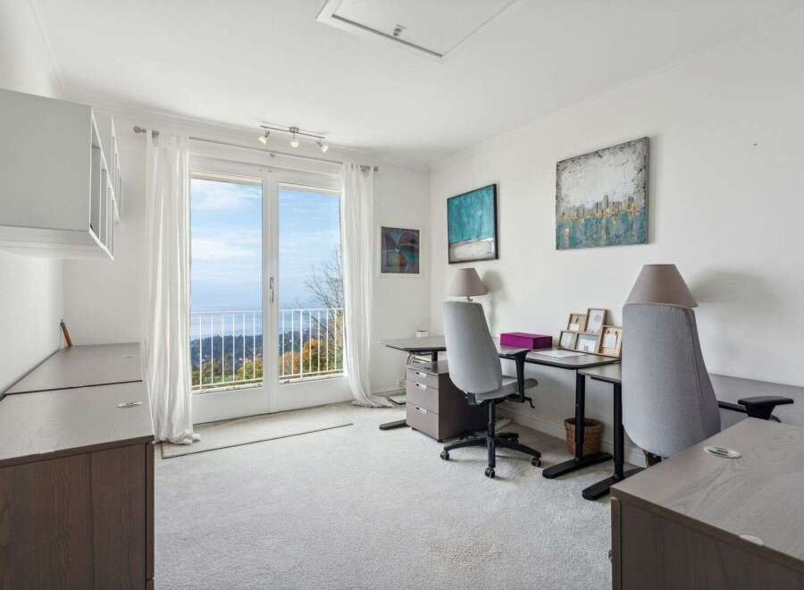 Enjoy breathtaking views from this stunning home office! This bright and airy space features a large window, perfect for letting in natural light and enjoying the scenery.