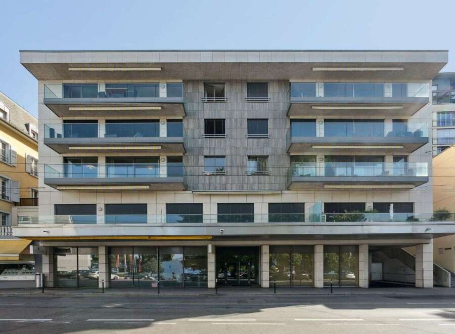Discover modern living in this stunning building, featuring sleek glass balconies and a contemporary facade.