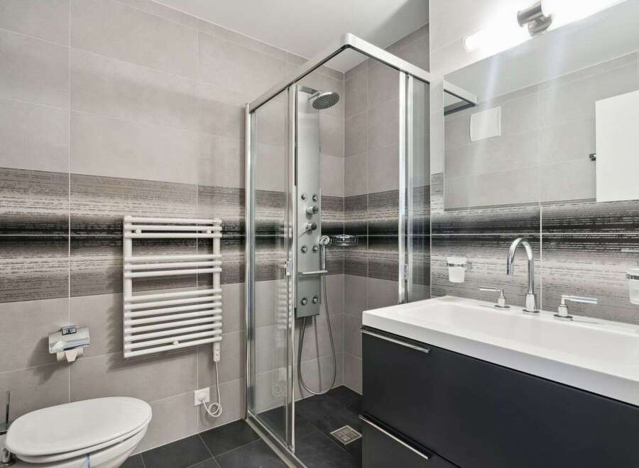 Step into a modern bathroom oasis! This stylish space features a sleek glass shower, a contemporary vanity, and elegant tile work.