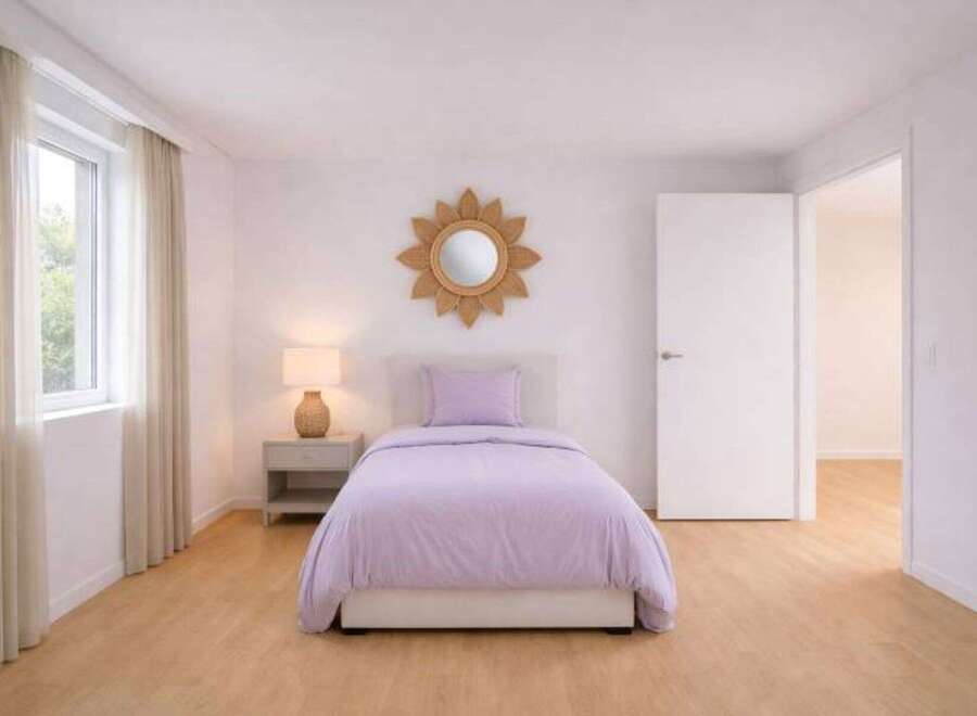 This inviting bedroom features a cozy single bed with a soft lavender comforter, creating a serene atmosphere.