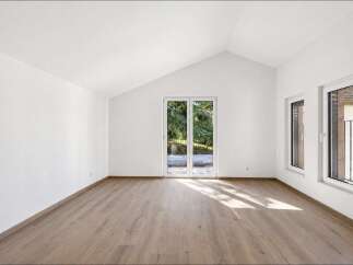 Experience modern living in this bright and airy room featuring a vaulted ceiling and abundant natural light.