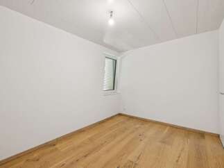 Experience modern living in this unfurnished room featuring pristine white walls and a light wood-paneled ceiling.