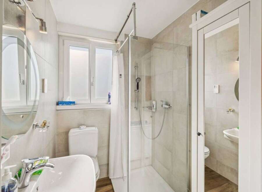 Step into this beautifully designed bathroom, featuring a modern shower and a convenient toilet.