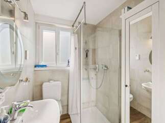 Step into this beautifully designed bathroom, featuring a modern shower and a convenient toilet.