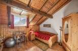 Discover the charm of this cozy bedroom featuring a unique wooden ceiling and walls, creating a warm and inviting atmosphere.